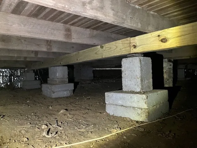 Pier and beam foundation with concrete block piers supporting wood floor beams in a crawlspace